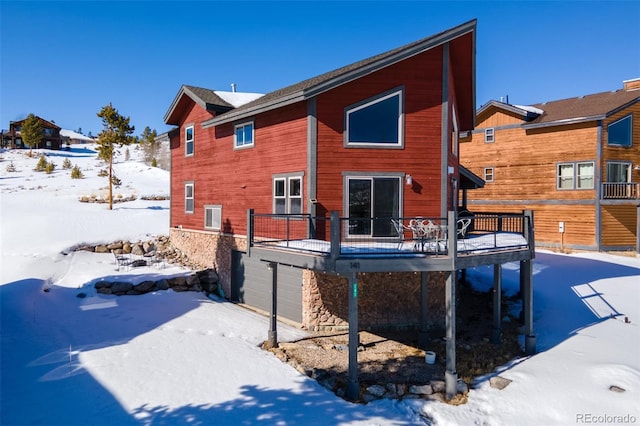 snow covered house featuring a deck