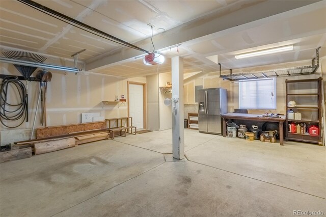 141 Gcr 4037, Grand Lake, CO 80447 - garage featuring stainless steel refrigerator with ice dispenser, a garage door opener, and a workshop area