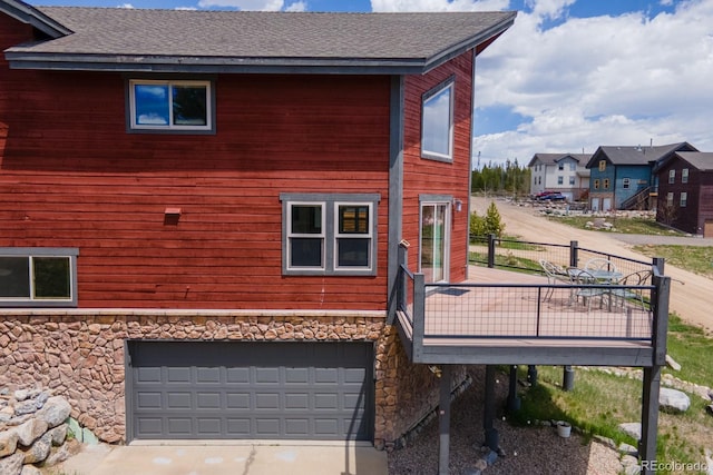 141 Gcr 4037, Grand Lake, CO 80447 - view of home's exterior with stone siding, roof with shingles, a deck, and a garage