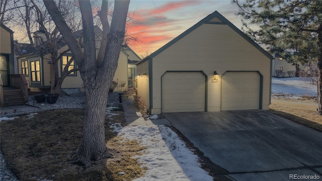 property exterior at dusk featuring an outbuilding and a detached garage