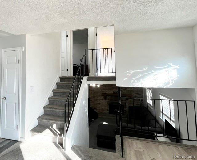 17413 E Louisiana Ave, Aurora, CO 80017 - staircase with wood finished floors, a textured ceiling, and baseboards