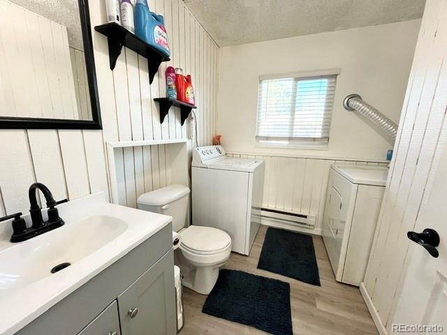 17413 E Louisiana Ave, Aurora, CO 80017 - bathroom featuring a baseboard radiator, wood finished floors, vanity, and toilet