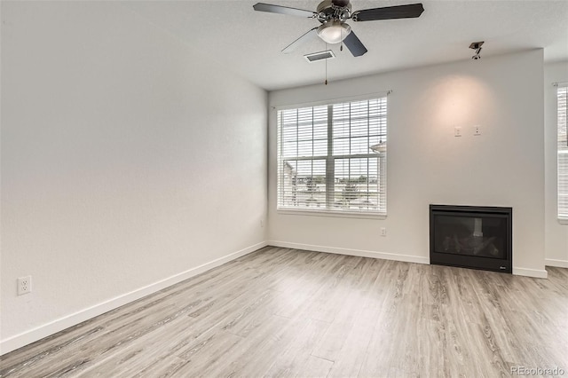 9185 Wilde Ln Unit 301, Parker, CO 80134 - unfurnished living room featuring wood finished floors, healthy amount of natural light, ceiling fan, and baseboards