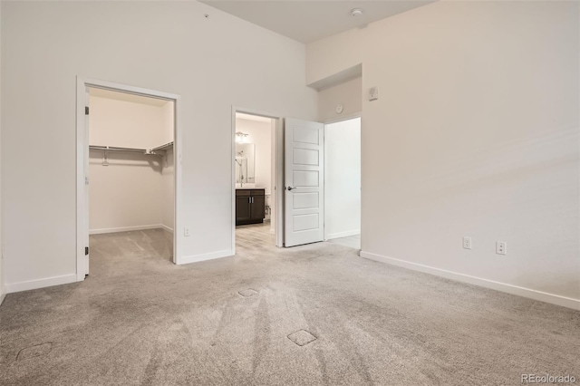 9185 Wilde Ln Unit 301, Parker, CO 80134 - unfurnished bedroom featuring light carpet, baseboards, a spacious closet, a towering ceiling, and a closet