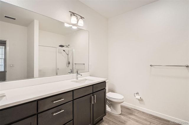 9185 Wilde Ln Unit 301, Parker, CO 80134 - full bathroom with toilet, a shower with shower door, wood finished floors, vanity, and baseboards