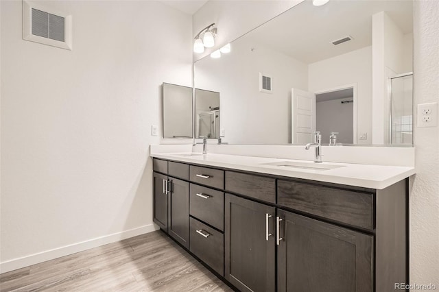 9185 Wilde Ln Unit 301, Parker, CO 80134 - full bath with double vanity, wood finished floors, baseboards, and a shower with shower door