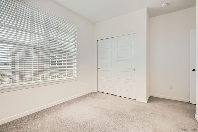 9185 Wilde Ln Unit 301, Parker, CO 80134 - unfurnished bedroom featuring light colored carpet, multiple windows, and baseboards