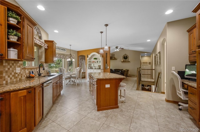 kitchen featuring a center island, sink, stainless steel dishwasher, pendant lighting, and a breakfast bar