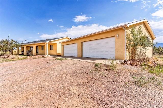 single story home featuring a garage and covered porch