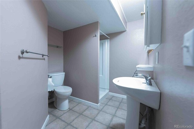 12242 Bannock Cir Unit D, Denver, CO 80234 - full bath with a shower stall, toilet, tile patterned floors, and baseboards