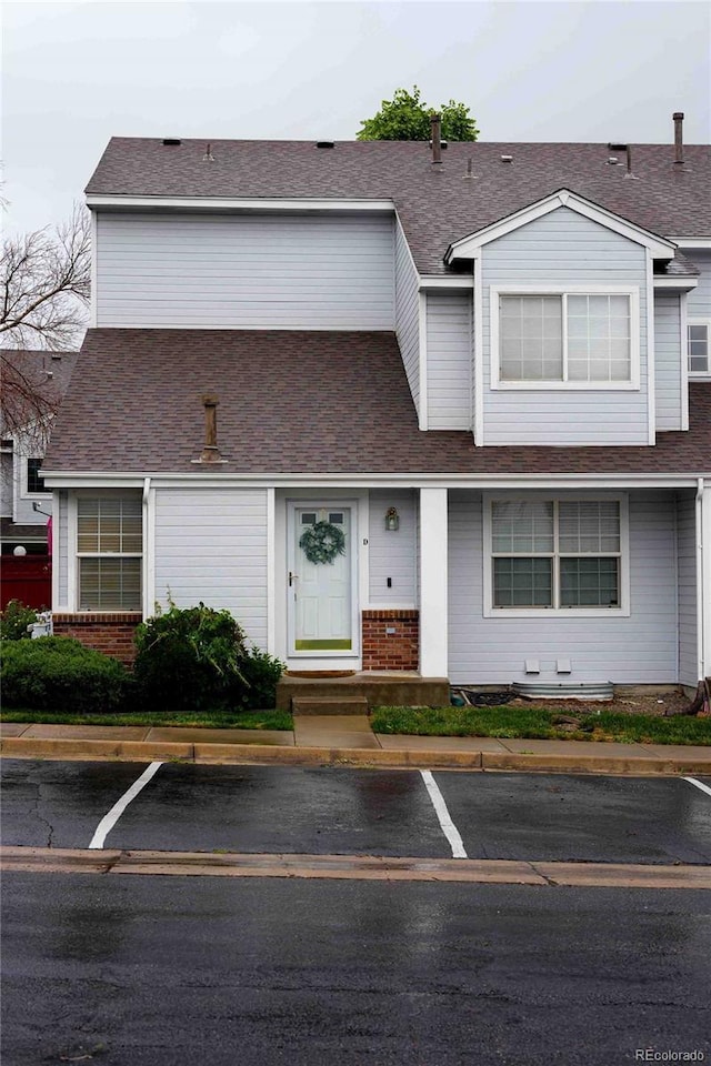 12242 Bannock Cir Unit D, Denver, CO 80234 - view of front of house with uncovered parking, brick siding, and a shingled roof