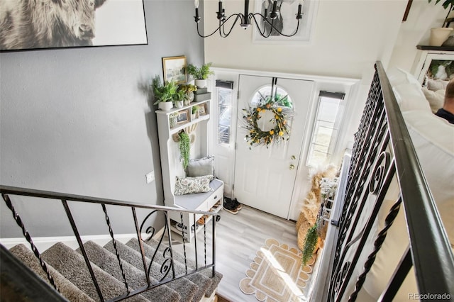 foyer with a chandelier, wood finished floors, and stairs