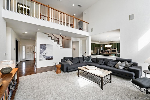 11985 Singing Winds St, Parker, CO 80138 - living room with stairway, a high ceiling, wood finished floors, carpet, and recessed lighting