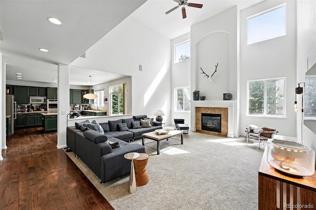 11985 Singing Winds St, Parker, CO 80138 - living room featuring a high ceiling, ceiling fan, a tile fireplace, recessed lighting, and dark wood-type flooring