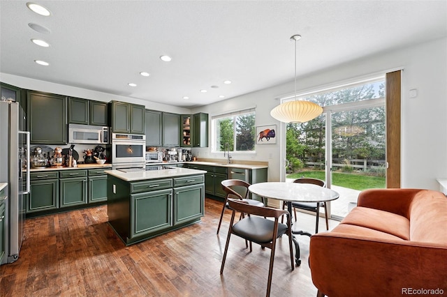 11985 Singing Winds St, Parker, CO 80138 - kitchen featuring green cabinets, stainless steel appliances, light countertops, dark wood-style floors, and recessed lighting