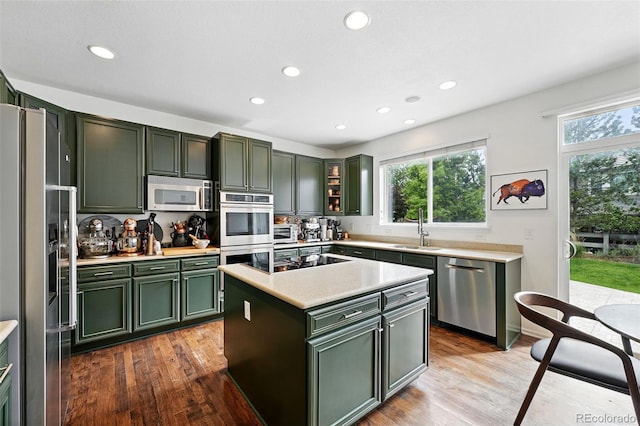 11985 Singing Winds St, Parker, CO 80138 - kitchen featuring green cabinetry, appliances with stainless steel finishes, a sink, light countertops, and recessed lighting