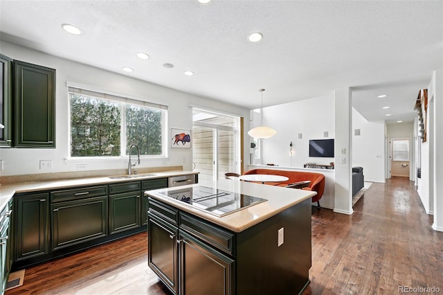 11985 Singing Winds St, Parker, CO 80138 - kitchen featuring a sink, black electric cooktop, green cabinetry, light countertops, and dark wood finished floors