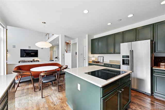 11985 Singing Winds St, Parker, CO 80138 - kitchen featuring high end refrigerator, black electric stovetop, wood finished floors, green cabinetry, and recessed lighting