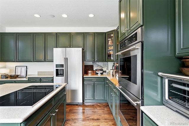 11985 Singing Winds St, Parker, CO 80138 - kitchen featuring appliances with stainless steel finishes, green cabinets, light countertops, recessed lighting, and wood finished floors