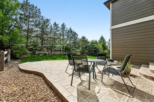 11985 Singing Winds St, Parker, CO 80138 - view of patio featuring outdoor dining area and view of wooded area