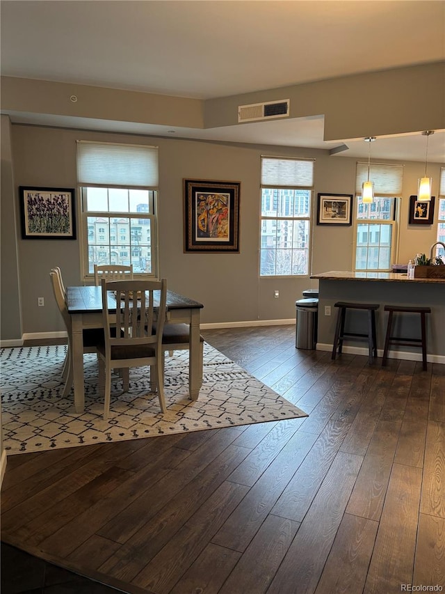dining room featuring a wealth of natural light, visible vents, dark wood finished floors, and baseboards