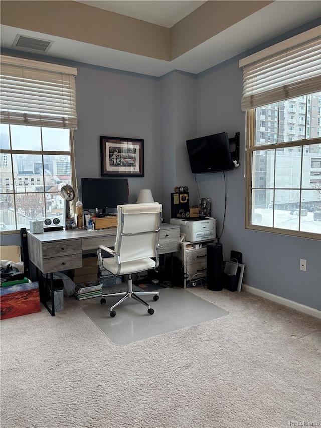 carpeted office featuring visible vents and baseboards