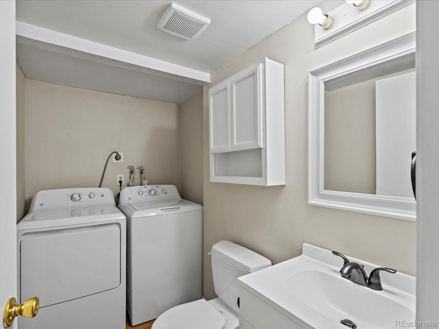 bathroom featuring vanity, toilet, visible vents, and washer and clothes dryer