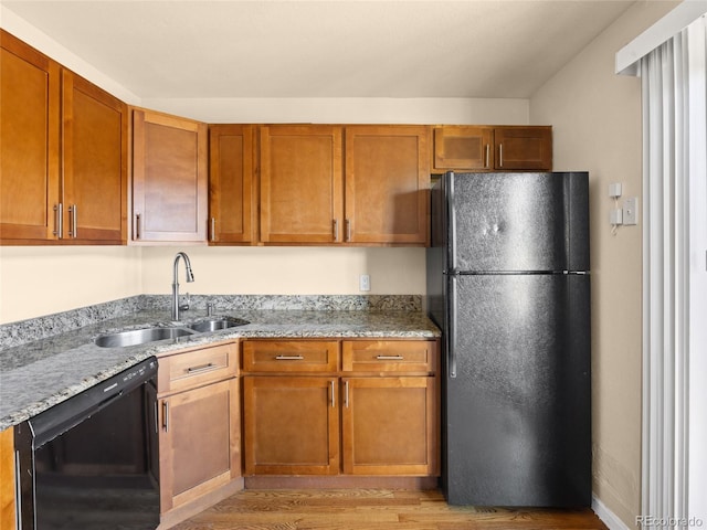 61 S Sable Blvd Unit C15, Aurora, CO 80012 - kitchen featuring black appliances, a sink, light wood finished floors, and light stone countertops