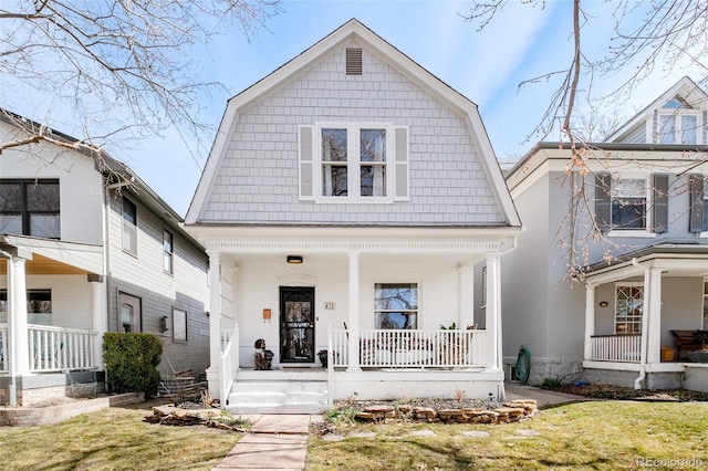 view of front of house featuring a gambrel roof, a front lawn, and covered porch