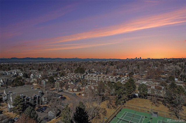 aerial view at dusk featuring a mountain view and a residential view