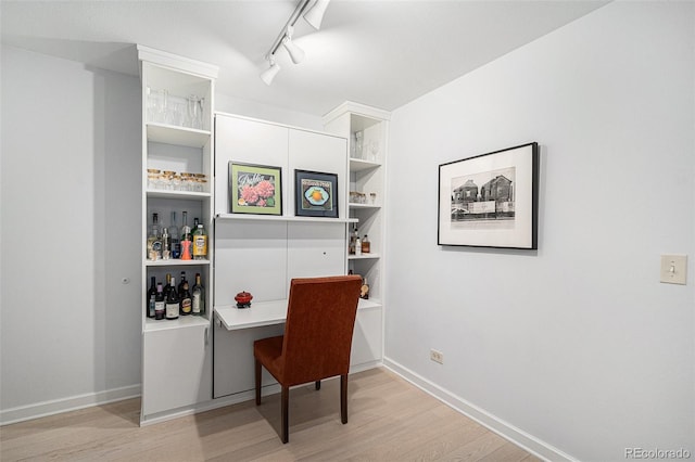 home office featuring rail lighting, light wood-style flooring, and baseboards