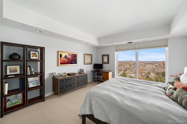 bedroom featuring baseboards, a raised ceiling, visible vents, and light colored carpet