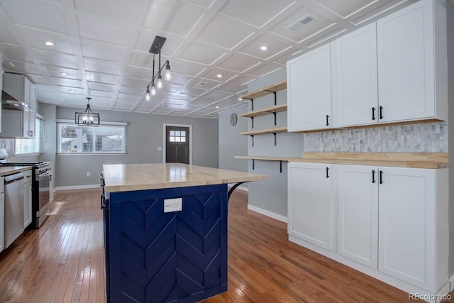 kitchen with a kitchen island, white cabinetry, pendant lighting, and stainless steel appliances