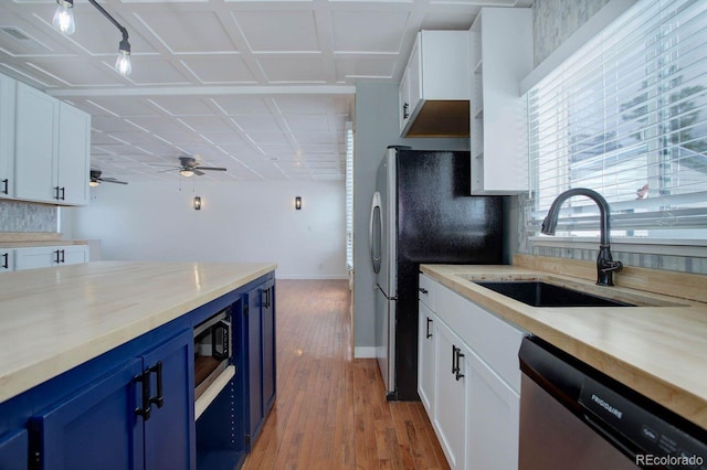 kitchen featuring blue cabinets, white cabinetry, appliances with stainless steel finishes, and sink