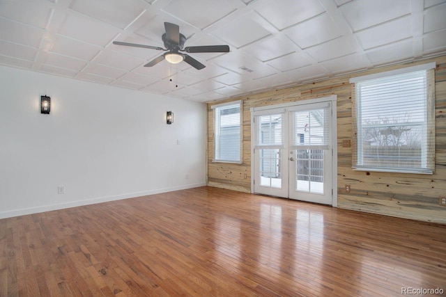 spare room featuring coffered ceiling, hardwood / wood-style floors, and french doors