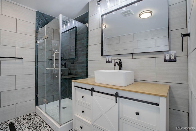 bathroom featuring tile walls, an enclosed shower, and vanity