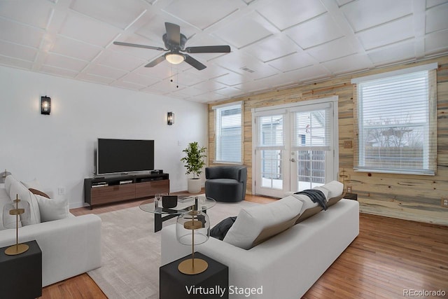 living room with coffered ceiling, wooden walls, and hardwood / wood-style flooring