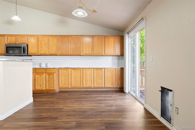 3461 Maple Cir, Brighton, CO 80601 - kitchen with stainless steel microwave, lofted ceiling, backsplash, dark wood finished floors, and hanging light fixtures