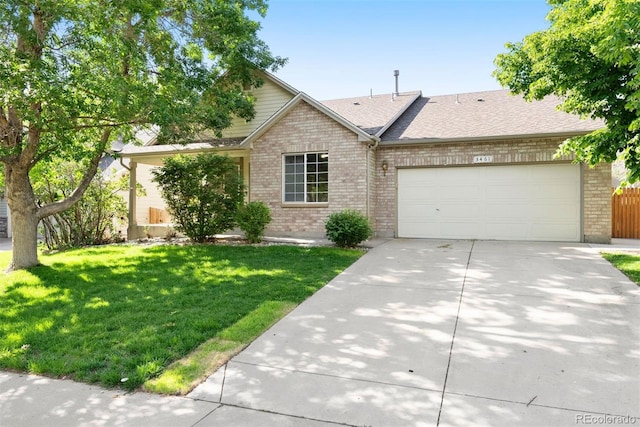 3461 Maple Cir, Brighton, CO 80601 - view of front of property with a garage, brick siding, concrete driveway, a front lawn, and roof with shingles