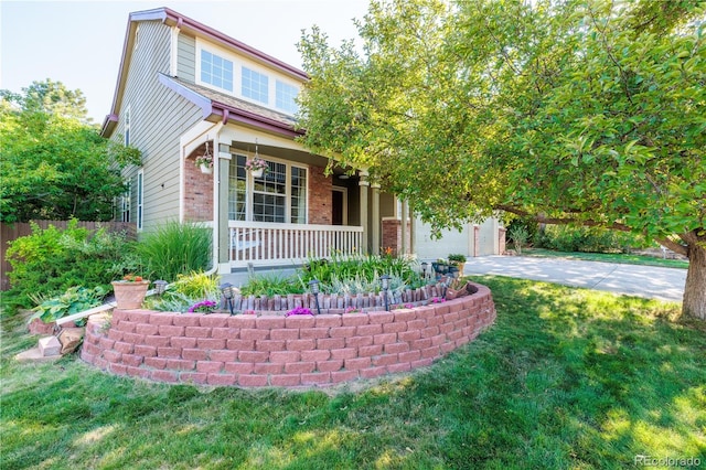 view of front of home featuring a garage, a front yard, and covered porch