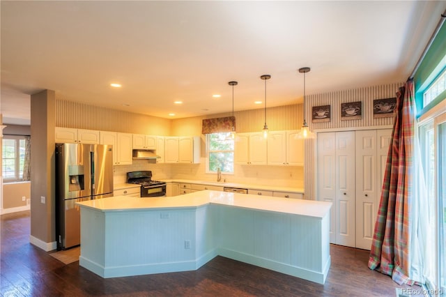 kitchen featuring stainless steel refrigerator with ice dispenser, sink, black gas range oven, a kitchen island, and white cabinets