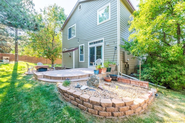 back of property with a wooden deck and a yard