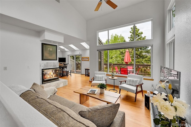 766 Chimney Creek Dr, Golden, CO 80401 - living area with a towering ceiling, a multi sided fireplace, ceiling fan, and light wood-style flooring