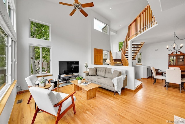 766 Chimney Creek Dr, Golden, CO 80401 - living room featuring a towering ceiling, light wood-style flooring, ceiling fan, a chandelier, and stairs