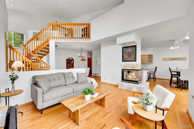 766 Chimney Creek Dr, Golden, CO 80401 - living area with stairway, a ceiling fan, a high ceiling, a multi sided fireplace, and light wood finished floors