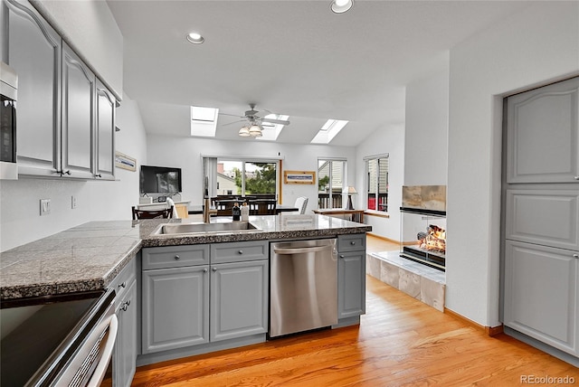 766 Chimney Creek Dr, Golden, CO 80401 - kitchen with a skylight, gray cabinetry, appliances with stainless steel finishes, a sink, and tile counters