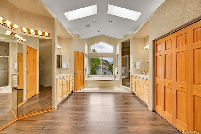 766 Chimney Creek Dr, Golden, CO 80401 - bathroom featuring a skylight, wood finished floors, two vanities, a bath, and lofted ceiling