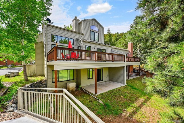 766 Chimney Creek Dr, Golden, CO 80401 - back of property featuring a wooden deck, a patio area, and a chimney
