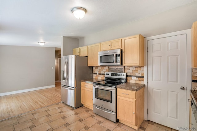 3216 Revere St, Aurora, CO 80011 - kitchen with stainless steel appliances, light brown cabinetry, tile counters, backsplash, and baseboards