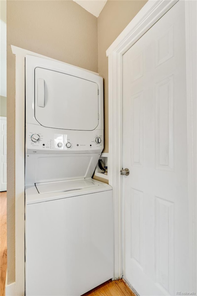 3216 Revere St, Aurora, CO 80011 - laundry room featuring estacked washer and dryer and light wood finished floors